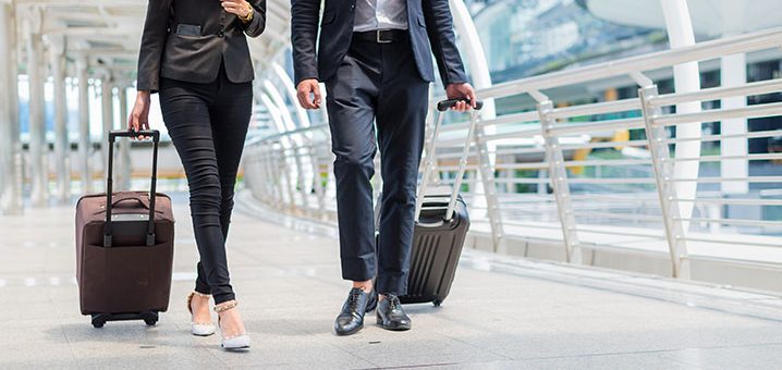 two people walking with suitcases