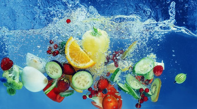 collection of high vitamin fruit and vegetables falling into water